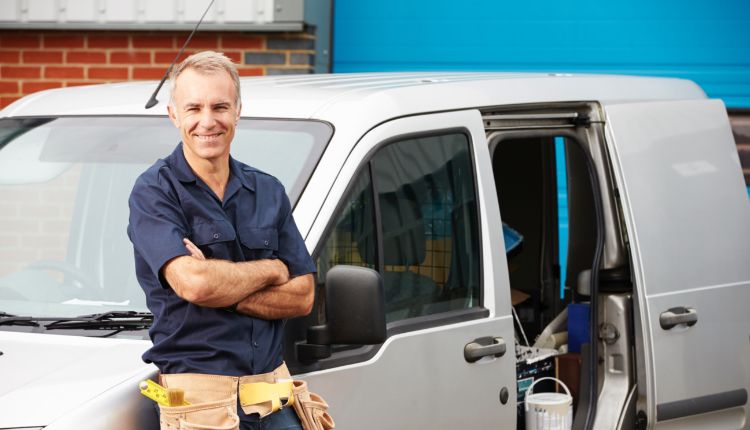 Contractor leaning on a van