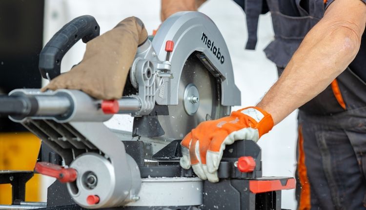 Carpenter using a compound miter saw